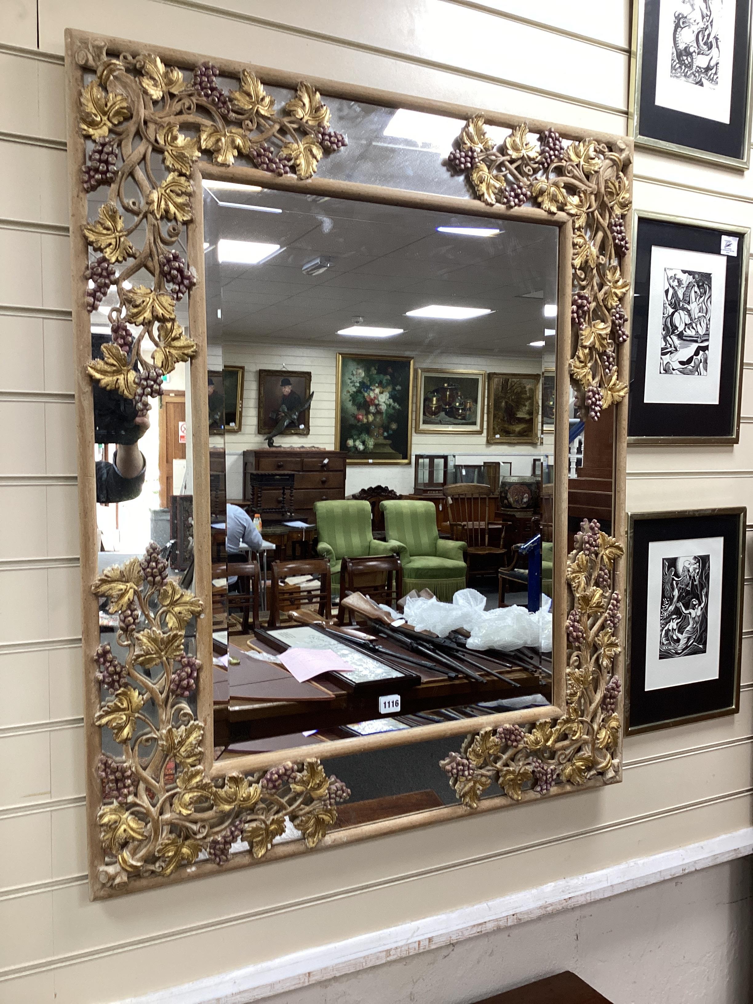 A rectangular marginal plate bevelled wall mirror, the part painted frame carved with grapes and vine leaves, width 86cm, height 105cm.